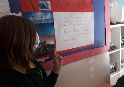 A person writing on a white boardDescription automatically generated